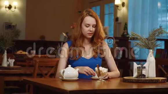 那个穿着蓝色连衣裙的红发美女坐在咖啡馆里喝着茶微笑着慢点视频的预览图