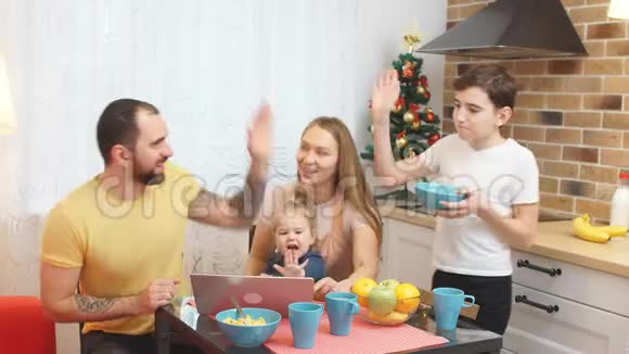 年轻的父母和孩子在厨房吃饭视频的预览图