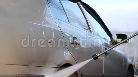 洗车一个人在水的压力下洗一辆车擦玻璃汽车护理概念视频的预览图