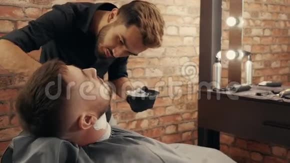 集中理发师在胡须上涂上泡沫视频的预览图