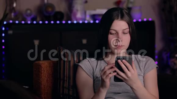 震惊女孩通过智能手机阅读信息在家拿着手机让年轻女人心烦意乱坏消息概念视频的预览图