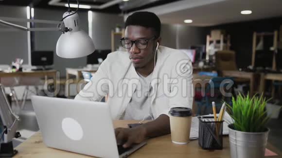 非洲商人用手提电脑喝咖啡视频的预览图
