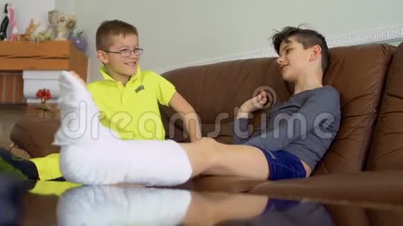 两个腿断了手的兄弟坐在家里的沙发上聊天视频的预览图