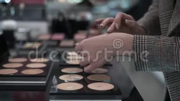 艾米的买家选择化妆粉底粉底在她的手以配合肤色在化妆品商店视频的预览图