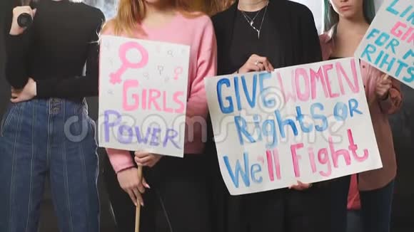 一群年轻的白种人女权主义者拿着海报站在烟雾弥漫的空间里笑着笑着视频的预览图