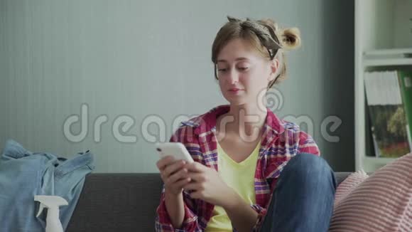 漂亮的年轻女子在清洁和使用完电话后正在沙发上休息视频的预览图