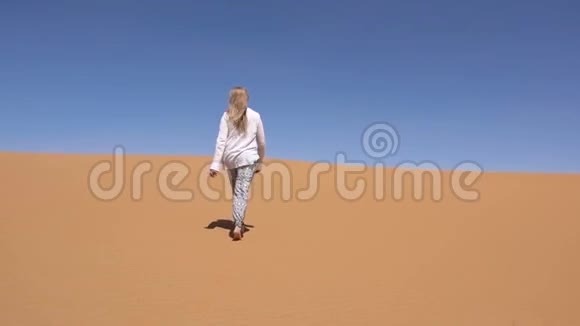金发女人沿着撒哈拉沙漠散步视频的预览图