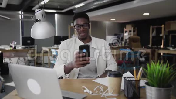 美国黑人年轻人在办公室使用电话视频的预览图