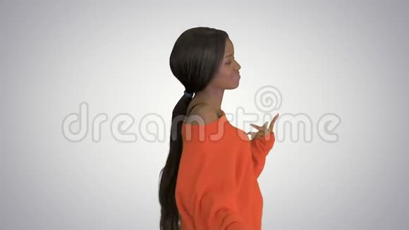 美丽的黑人女人在渐变的背景下微笑和跳舞视频的预览图