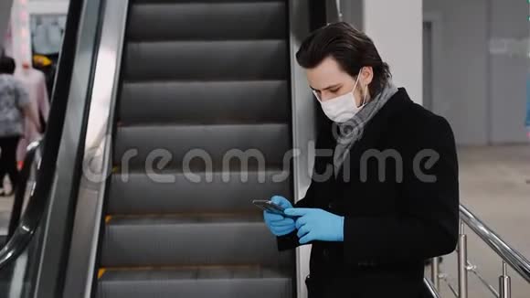 男子戴着医用口罩和手套以防止COVID19冠状病毒流行并拨打手机视频的预览图