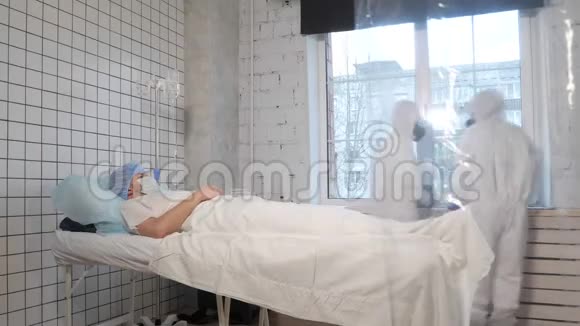躺在病床上的人危险物质无菌服的医生视频的预览图
