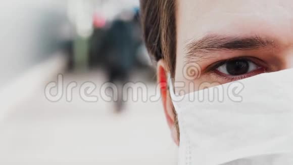 一个戴着医用面罩的男人的眼泪眨着眼睛以防止COVID19冠状病毒视频的预览图