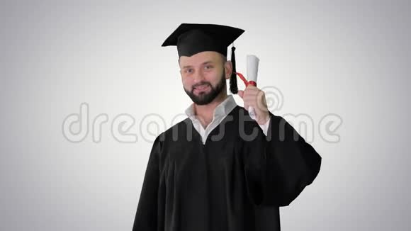 年轻的男性微笑毕业生显示拇指在梯度背景视频的预览图