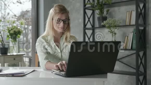 在线服务一位成功的女企业家在办公室的电脑上工作鲜花在网上检查视频的预览图