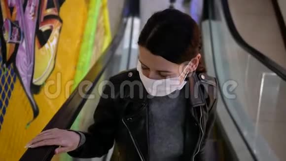在商店里戴防护面罩的年轻女人它在自动扶梯上视频的预览图