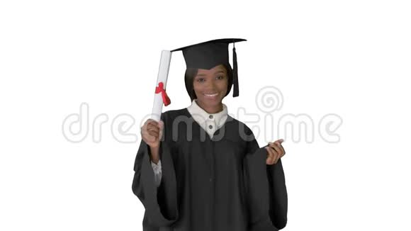 美丽的学生微笑而她的毕业帽和长袍在白色的背景视频的预览图