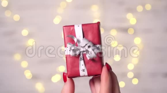 女人的特写她的手指拿着一小盒礼物视频的预览图