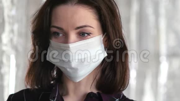 悲伤的女人带着面具看着镜头冠状病毒COVID19传播预防理念视频的预览图
