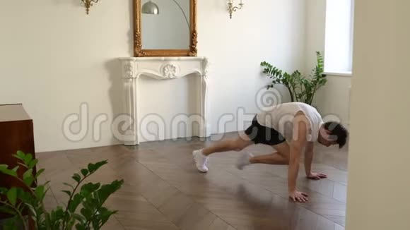 英俊的年轻运动员在家锻炼身体在木板位置做有氧运动视频的预览图