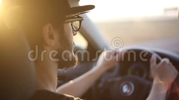 特写小胡子男驾驶汽车具有日落的阳光效果视频的预览图