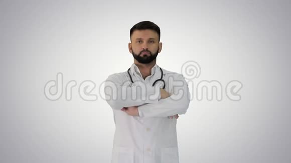 年轻的男性白种人医生站在梯度背景上双手交叉视频的预览图