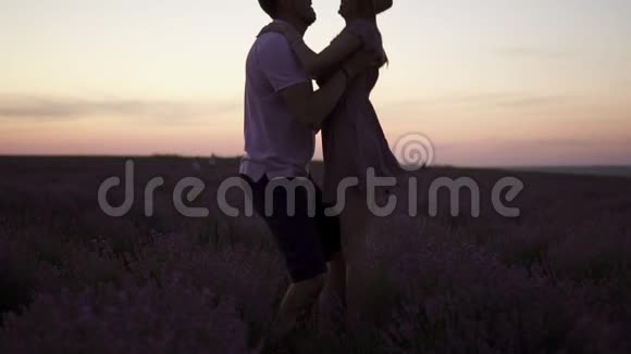 夕阳下一个年轻人抱着女朋友站在一片盛开的薰衣草地上视频的预览图