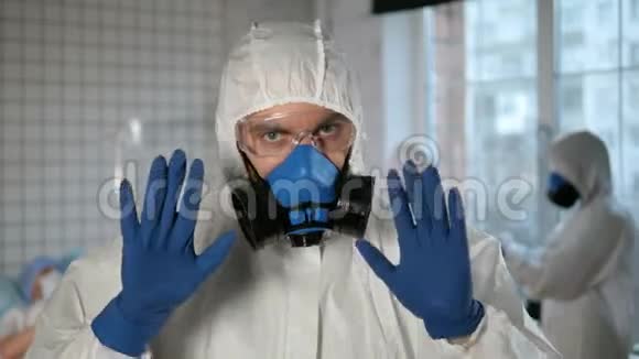 医生戴着呼吸器和防护服对着镜头做停止手势别担心医院视频的预览图
