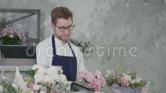 鲜花精品店男女平等的微笑男士代表向迷人的买家出售美丽的花束视频的预览图