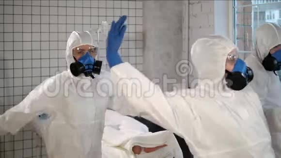 一队穿着防护服的医生在医院的孤立病人面前跳舞视频的预览图