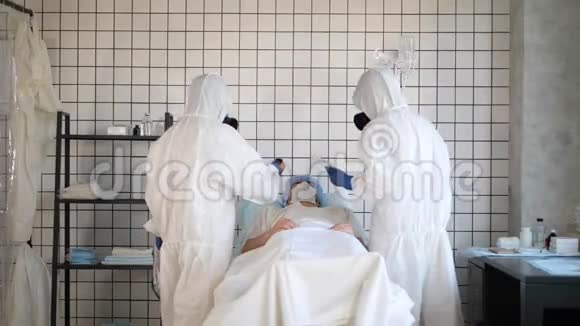 穿着危险品无菌服的医生在医院测量病人的体温视频的预览图