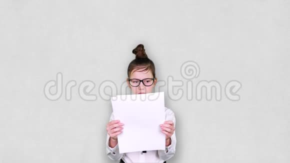 十几岁的女孩愤怒地把白纸撕成小块把它们扔了起来女孩戴眼镜是视频的预览图