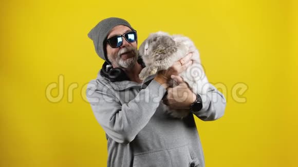 戴墨镜的大胡子男和一只宠物兔子说话视频的预览图