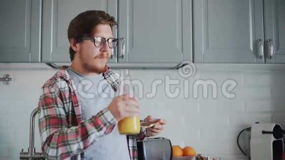 年轻人吃着带有巧克力糊的吐司喝着橙汁视频的预览图