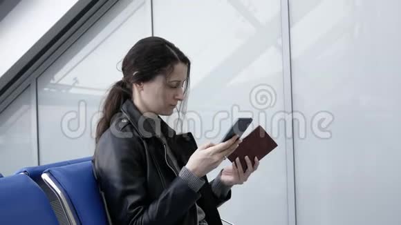 年轻女子在机场通过电话购买机票她输入护照资料购买机票视频的预览图