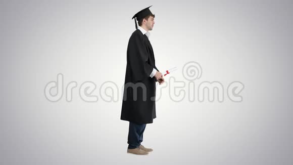 穿毕业礼服的男人在渐变背景下为镜头摆姿势视频的预览图