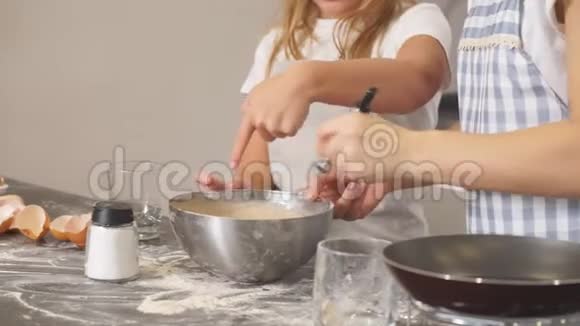 年轻的厨师们正在准备蛋糕小女孩品尝面团视频的预览图