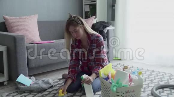 年轻的女人用特殊的洗涤剂清洗地毯视频的预览图