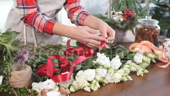 年轻的女花匠带着红色的花带视频的预览图