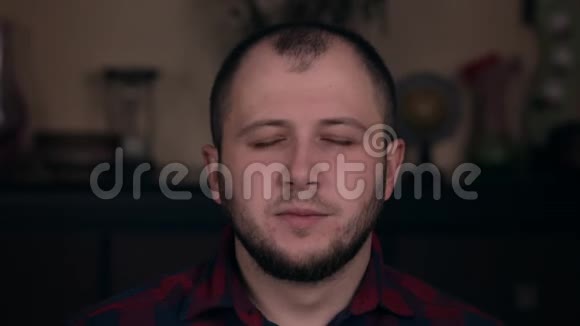 一个穿格子衬衫特写的欧洲年轻人打着哈欠情感的概念视频的预览图