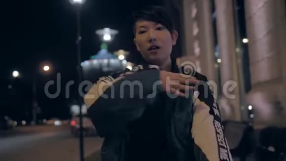 非常时尚的亚洲女孩晚上在城市街道上跳舞令人印象深刻的韩国女孩视频的预览图