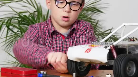 小男孩在家修理一辆无线电控制的汽车模型视频的预览图