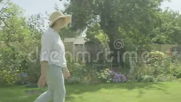 年长的女人穿过她的花园视频的预览图