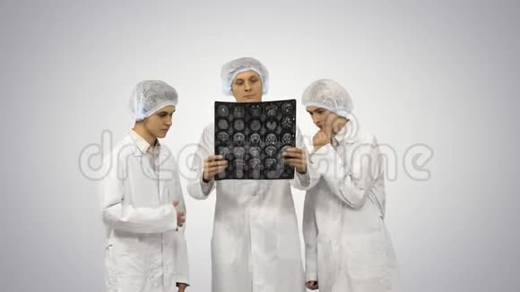 三位医生有节奏地在渐变背景下观察一位病人的x光照片视频的预览图