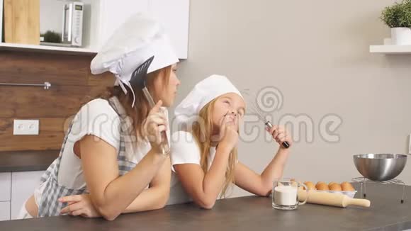 一个年轻的白种人家庭站在厨房里穿着围裙思考着该为节日烤些什么视频的预览图