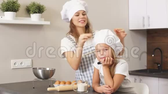 年轻的金发女人和孩子在烤蛋糕之前视频的预览图