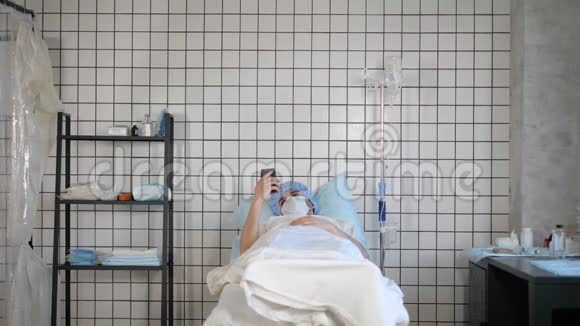 男性病人躺在床上时拿着手机视频的预览图