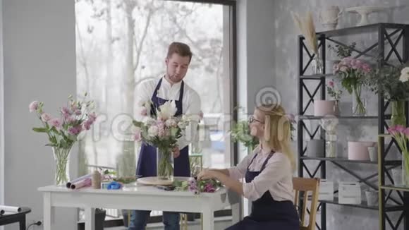年轻友好的专家女性和男性同事在花店里美丽的鲜花和鲜花视频的预览图