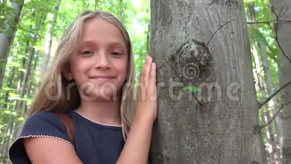 森林中的孩子大自然中的孩子冒险户外的女孩树后视频的预览图