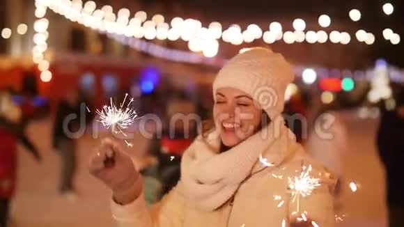 寒假概念年轻美丽快乐的微笑女孩拿着火花视频的预览图