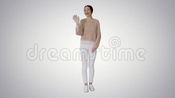 快乐的年轻女子挥手在渐变的背景上迎接你视频的预览图